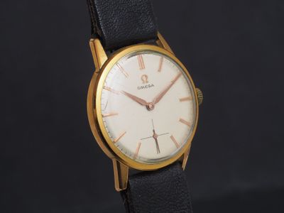 une image représentant une montre dorée et noire sur fond noir