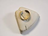 a white object with a gold ring on top of it