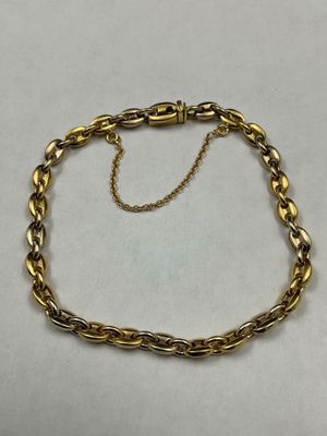 a close up of a gold chain bracelet on a white surface