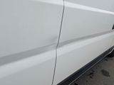 a close up of a white van parked on the side of the road