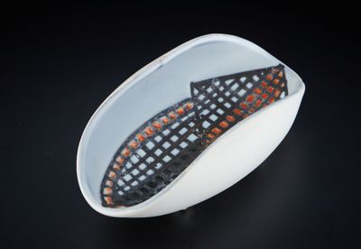 un bol blanc orné d'un motif noir et orange