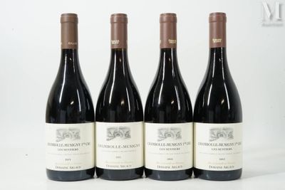 trois bouteilles de vin rouge sont alignées sur une surface blanche