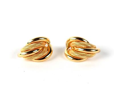 une paire de boucles d'oreilles dorées ornées d'un motif en forme de nœud