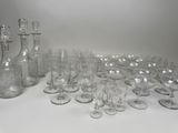 a lot of wine glasses and a bottle on the table