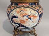 un vase orné d'une bordure dorée et d'un motif bleu et orange