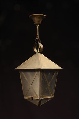 an old brass lantern hanging from the ceiling in a dark room