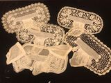 four pieces of white lace on a black surface