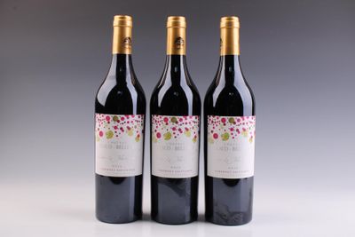 trois bouteilles de vin posées sur une table l'une à côté de l'autre