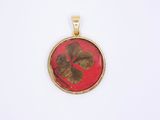 a close up of a red and gold pendant with a butterfly on it
