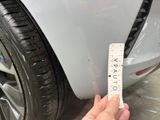 someone is measuring the width of a car ' s tire with a ruler