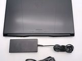 a laptop with a charger and power cord on the table