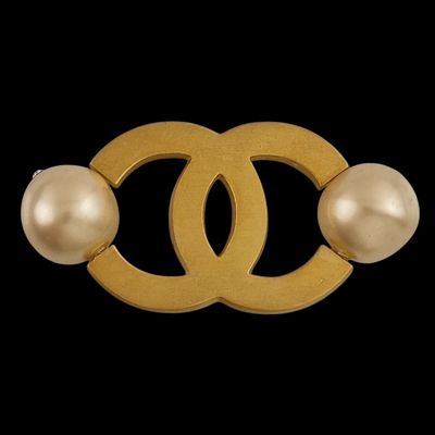 a gold and pearl broochle with two pearls