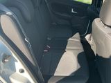 the back seats of a silver car are empty in the parking lot