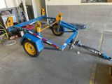 a blue trailer with yellow wheels in a garage