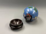 a blue ball and a small metal bowl on a table