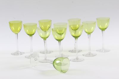 seven wine glasses in a row on a white surface