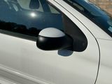 une voiture blanche garée devant un mur de briques