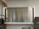 a stainless steel refrigerator in a kitchen with a window