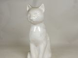 a white cat figurine sitting on a white surface