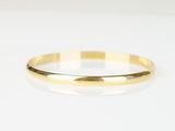 gros plan d'une bague en or sur une surface blanche