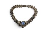 un gros plan sur un bracelet orné d'une pierre bleue