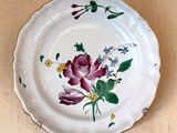 a plate with flowers painted on it sitting on a table
