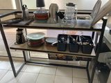 un chariot de cuisine sur lequel sont posés de la vaisselle et des ustensiles