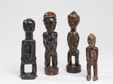 un ensemble de quatre figurines en bois sculptées, de formes et de tailles différentes