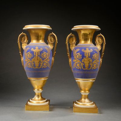 paire de vases bleus et dorés munis d'anses et posés sur des socles