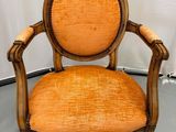 fauteuil rembourré orange dans un coin d'une pièce aux murs blancs