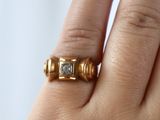 la main d'une femme tenant une bague sertie d'un diamant