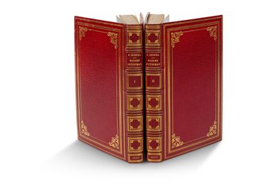 un livre ouvert, à la couverture rouge, posé sur une surface blanche