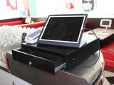un ordinateur portable posé sur une caisse enregistreuse dans un snack-bar