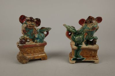 paire de figurines en céramique représentant un homme et une femme assis sur une boîte