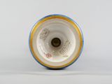 underside view of a blue and white vase with a yellow rim