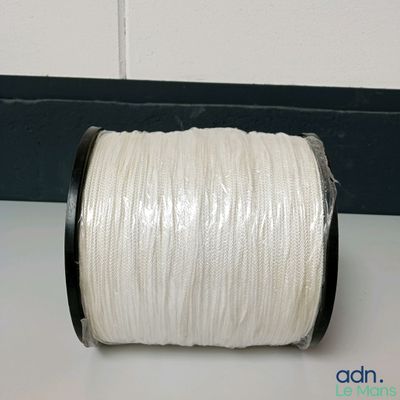 une image représentant une bobine de fil blanc posée sur une table