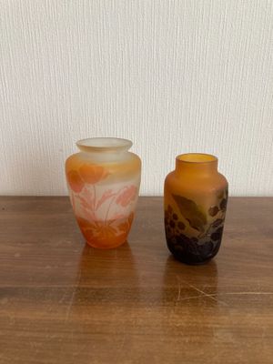 two vases sitting on a wooden table next to each other