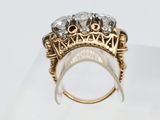 a close up of a gold and diamond ring on a clear surface