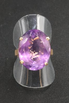 an amethorate ring on a black surface with a gold band