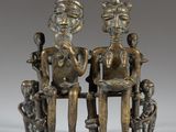 two bronze figurines of two people sitting on a bench