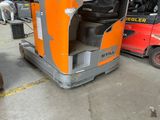 un chariot élévateur orange garé à côté d'un camion rouge