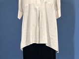 a white shirt and black pants on a mannequin stand