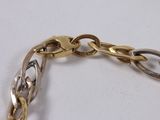 two tone gold and silver link bracelet on a white surface