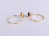 a pair of gold rings with a black stone on top