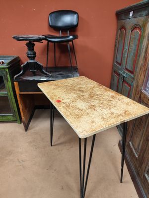 une petite table aux pieds en épingle à cheveux, dans un coin de la pièce