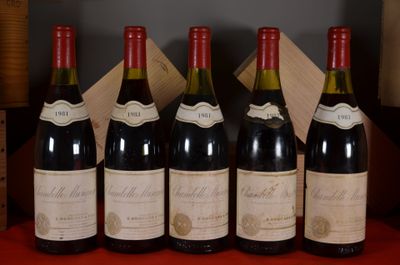Six bouteilles de vin rouge sont alignées sur une table rouge.