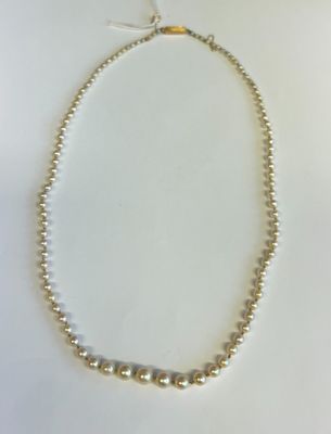 gros plan d'un collier de perles sur une surface blanche