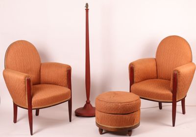 deux chaises orange et un tabouret dans une pièce aux murs blancs