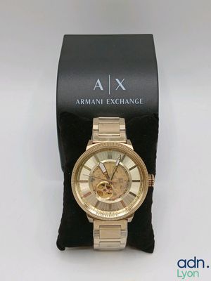 an image of a gold wrist watch sitting on a black box