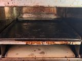 a dirty oven with a metal shelf in it